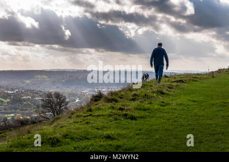 L'uomo cammina cane su Little Solsbury Hill, Batheaston, bagno, Somerset, Inghilterra, Regno Unito Foto Stock