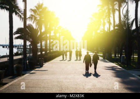 Strada con alberi di palma con pochi turisti Foto Stock