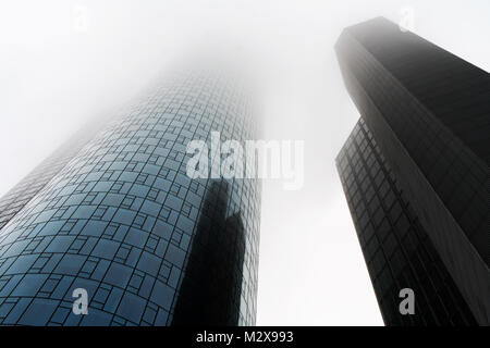 Basso angolo di visione dei due grattacieli avvolto nella nebbia o foschia nel quartiere finanziario di Francoforte Germania