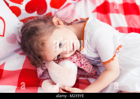 Riproduzione di Cute girl sul letto Foto Stock