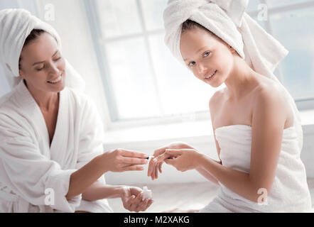 Allegro giovane ragazza avente la sua manicure fatto Foto Stock