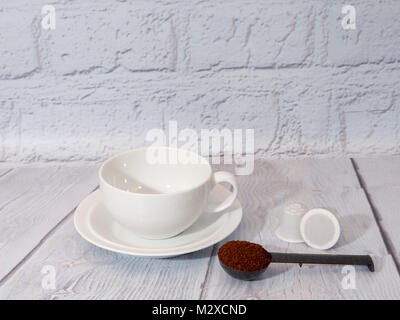 Bianco una tazza di caffè con una dose di polvere di caffè e bianco generico nespresso montare le cialde di caffè Foto Stock