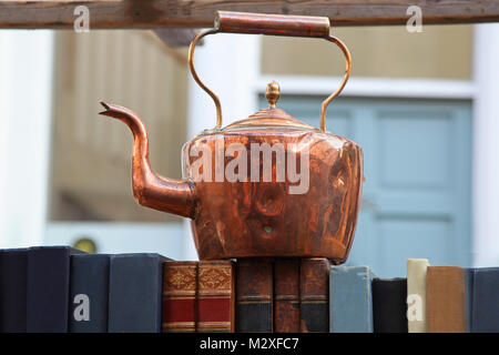 Teiera in bronzo sulla sommità dei vecchi libri su antiche fuori mercato Foto Stock