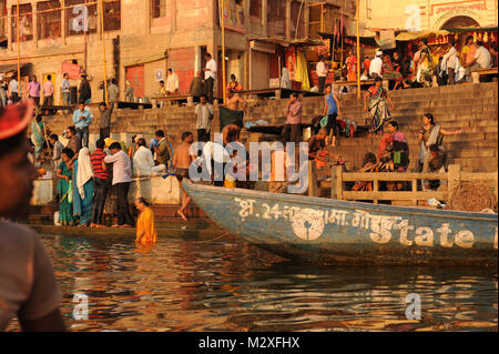 I devoti sulle rive del fiume Gange prendere un santo dip in Varanasi, India Foto Stock
