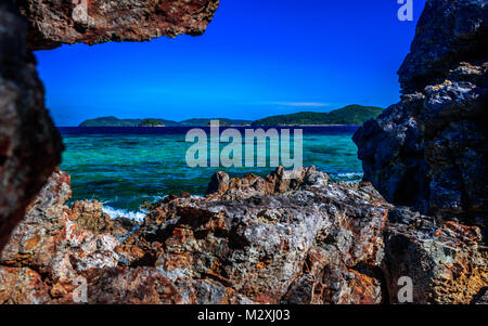 Isola vulcanica nelle acque blu Foto Stock