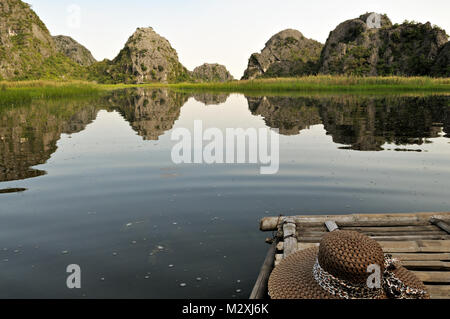 Hat su una barca in Van lungo la Riserva Naturale, Ninh Binh, Provincia del Vietnam del nord Foto Stock