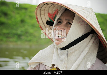 Ritratto di una donna vogatore in Van lungo la Riserva Naturale, Ninh Binh, Provincia del Vietnam del nord Foto Stock