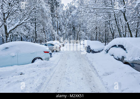 Vetture sotto la neve sulla winter city street. Foto Stock