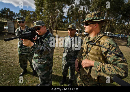 Da funzionari dell Esercito di Liberazione del Popolo di Pechino Regione Militare, Repubblica Popolare di Cina, discutere di precisione di tiro con U.S. Il personale marino Sgt. Travis W. Hawthorne (destra) guardando attraverso il sistema ottico di un M4 service fucile durante il 2012 Esercito Australiano specialità con bracci riunione (AASAM) 12 maggio nel Puckapunyal, Australia. AASAM è un rendimento di tiro internazionale di concorrenza costituito da 16 diversi paesi. Questo anno è la quinta iterazione del AASAM e il terzo anno consecutivo che negli Stati Uniti le forze sono stati invitati a partecipare. Oltre ad essere un tiratore scelto la concorrenza AASAM è Foto Stock