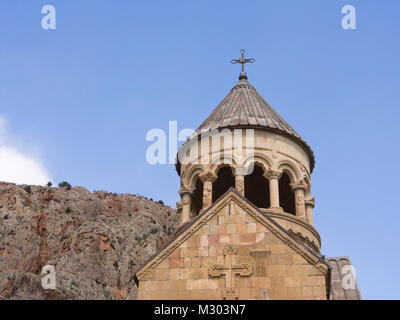 Monastero di Noravank nel sud dell'Armenia, facciata dettaglio della Surb Astvatsatsin chiesa rossa con pareti di roccia e cielo blu Foto Stock