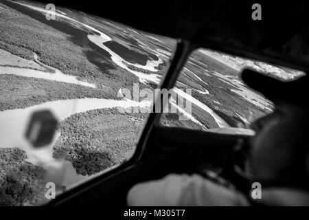 Un colombiano pilota della compagnia aerea effettua una manovra di terra un Douglas DC-3 velivolo tra i canali del fiume all'aeroporto di Barranco Minas, Colombia. Foto Stock