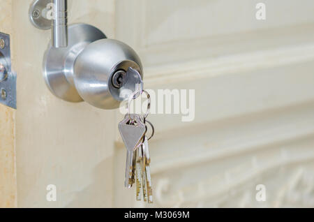 Manopola di sbloccaggio uso a mano la chiave per sbloccare la manopola della porta della porta della porta di legno bianco porta in acciaio inox la manopola o la maniglia, manopola di presa porta mano premere il pomello di bloccaggio delle porte Foto Stock