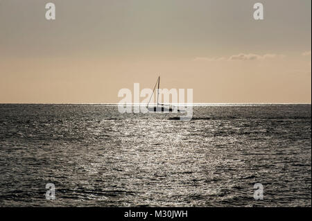 Imbarcazione a vela crociere al tramonto sulle rive di Lahaina, Maui, Hawaii Foto Stock