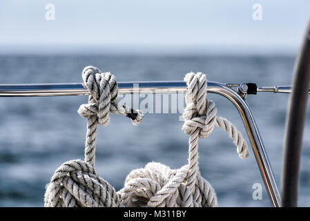 Linee di ormeggio appesa la bobinatura su uno yacht a vela sull'oceano Foto Stock