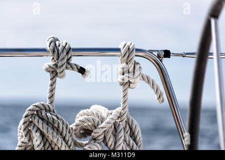 Linee di ormeggio appesa la bobinatura su uno yacht a vela sull'oceano Foto Stock