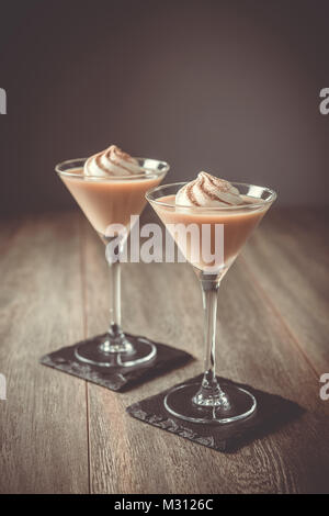 Due Irish cream liquori con un moto vorticoso della crema di latte Foto Stock