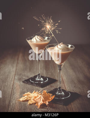 Due bicchieri di liquore Irish cream con sparkler per una celebrazione Foto Stock