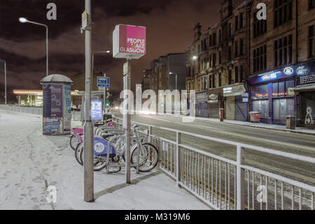 Bicicletta pubblica stazione di noleggio di notte dopo una caduta di neve in Glasgow, Scotland, Regno Unito. Foto Stock