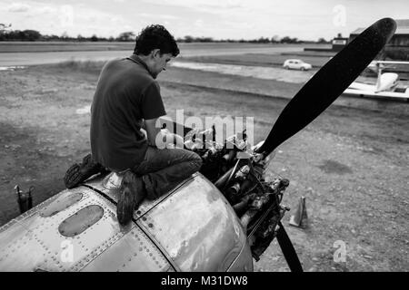 Un colombiano lavori meccanici su un motore durante una routine di controllo di manutenzione di un Douglas DC-3 velivolo all'aeroporto di Villavicencio (Colombia). Foto Stock