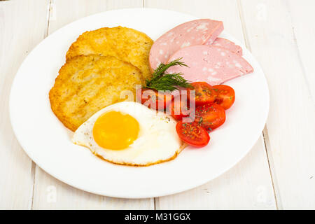 Frittelle di patate, uova fritte, salsicce a colazione Foto Stock