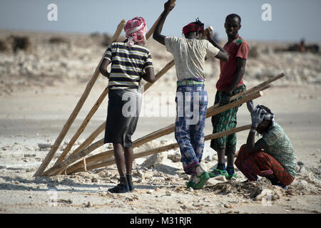 Un lontano gli uomini allentare il suolo per consentire la miniera di sale di Danakil deserto, regione di Afar, Etiopia. Foto Stock