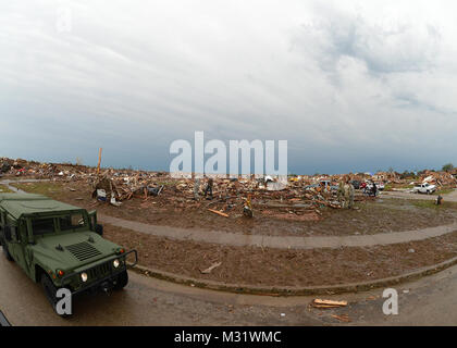 Dopo il devastante tornadic attività in Moore, Okla., un militare e applicazione della legge presenza contribuisce a frenare la presenza prolungata e mantiene la sicurezza nella zona il 21 maggio 2013. Questo ha stabilito inoltre di alloggiamento è ora una terra desolata dopo una massiccia tornado ha colpito la zona del 20 maggio lasciando livellato case, aziende e scuole nella sua scia. (US Air Guard Foto di Tech. Sgt. Roberta A. Thompson)(RILASCIATO) Guardie aiutando tornado vittime 006 da Oklahoma Guardia Nazionale Foto Stock