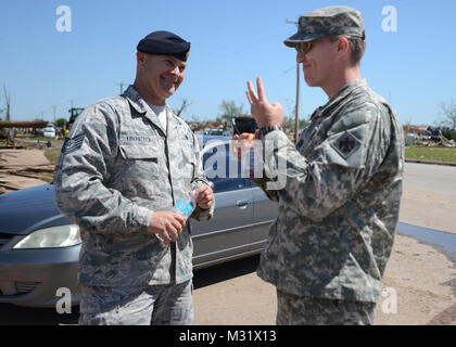 Cappellano Capt. David Jordan, società A, 1° Battaglione, 279th battaglione di fanteria, amuses Tech. Sgt. Ben Kirkpatrick, 138th Fighter Wing forze di sicurezza, come egli condivide una storia il Maggio 22, 2013 in Moore, Okla. Cappellano della Giordania ha visitato l'entrata dei punti di controllo presidiata da esercito e guardie di aria nella zona colpita da una migliorata su scala Fujita 5 tornado il 20 maggio per garantire una forte morale. Okla Nat'l cappellani di guardia 007 da Oklahoma Guardia Nazionale Foto Stock