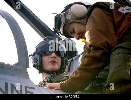 971118-N-1386C-356 (novembre 18th, 1997) sul bordo della nuclear powered portaerei USS Nimitz CVN (68) operanti nel Golfo Persico. . . . Lt. Chris Schnoebel da Seattle, lavaggio, riceve last minute assistenza con i cavi elettrici e sistemi di ritenuta sedile prima di decollare da ÒPlane CaptainÓ Airman Zarina Ahmadzai da New York, NY. Entrambi sono assegnati a squadron Strike Fighter Squadron uno quattro sei (VFA-146). Nimitz e la sua avviato Carrier aria Wing nove (CVW9), è attualmente operativo nel Golfo di imporre delle sanzioni delle Nazioni Unite contro l'Iraq, da pattugliamento Òno-fly zoneÓ sotto funzionamento ÒSouthern Watc Foto Stock