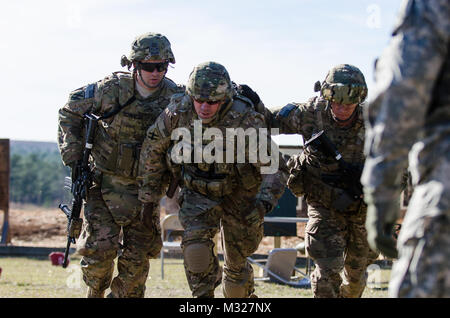 La Georgia Guardia nazionale, 48th della brigata di fanteria combattere Team Sgt. Zachary Schroeder, 1Lt. Geremia Stafford e Sgt. Daniel Lavelle pratica la scorta e la protezione di una chiave del leader in una situazione di ostilità durante la mobilitazione di formazione presso il Camp Shelby forze congiunte Training Center. Muovendo da coprire con la Georgia la Guardia Nazionale Foto Stock