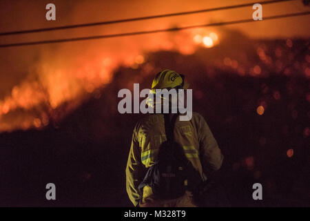 Chino Valley vigili del fuoco guarda le fiamme che sopraggiungono del Thomas il fuoco dal cantiere di una casa a Montecito, California, Dic 12, 2017. C-130Js dell'146Airlift Wing a Isole del Canale Air National Guard Base in Port Hueneme, eseguito il Modular Airborne sistema antincendio e gocciolata Fire Suppression sostanze chimiche sul fuoco il percorso per rallentare il suo avanzamento a sostegno dei vigili del fuoco sulla terra. (U.S. Air Force foto di J.M. Eddins Jr.) 171211-F-BP133-278.jpg da AirmanMagazine Foto Stock