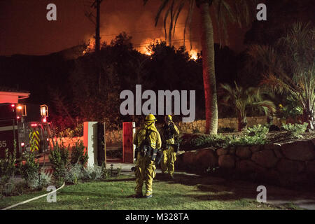 Chino Valley vigili del fuoco guarda le fiamme che sopraggiungono del Thomas il fuoco dal cantiere di una casa a Montecito, California, Dic 12, 2017. C-130Js dell'146Airlift Wing a Isole del Canale Air National Guard Base in Port Hueneme, eseguito il Modular Airborne sistema antincendio e gocciolata Fire Suppression sostanze chimiche sul fuoco il percorso per rallentare il suo avanzamento a sostegno dei vigili del fuoco sulla terra. (U.S. Air Force foto di J.M. Eddins Jr.) 171211-F-BP133-384.jpg da AirmanMagazine Foto Stock