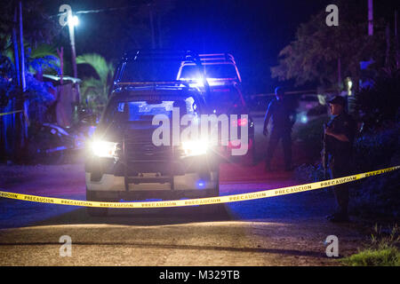 Gli ufficiali di polizia a guardia della scena di un tiro in Puerto Morelos, Messico, sulla luglio 11, 2017. Un uomo è stato ucciso ed un altro è stato gravemente ferito. I media locali hanno chiamato il tiro di un assassinio. La violenza in Messico spiked nel 2017 con più di 12.000 omicidi nei primi sei mesi, lasciando molti a mettere in discussione il futuro di questa famosa zona turistica. Foto Stock