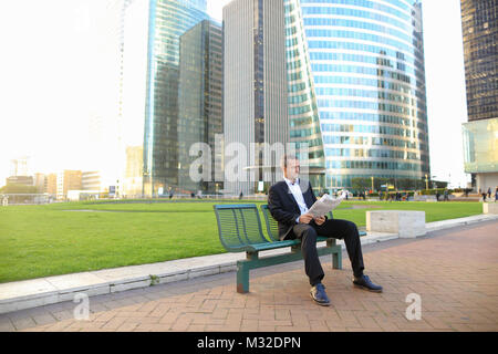 Allietano manager maschio quotidiano di lettura al di fuori di . Foto Stock