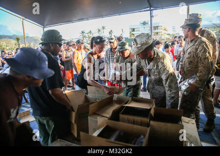 Stati Uniti Marines contribuire a distribuire cibo alla gente del posto in corrispondenza di un rifugio in Saipan, e il Agosto 9, 2015. I marines con società di Echo, Battaglione Team di atterraggio secondo battaglione, 5 Marines, 31 Marine Expeditionary Unit, stanno aiutando gli enti locali e le agenzie federali con typhoon soccorsi in Saipan dopo l'isola fu colpito dal tifone Soudelor, 2-3 agosto. Il MEU, insieme con gli Stati Uniti Navi della Marina militare del Bonhomme Richard anfibio gruppo pronto, stava conducendo la formazione in prossimità delle Isole Marianne quando esso è stato reinstradato per assistere in Saipan. (U.S. Marine Corps photo Cpl. Ryan C. Rete/RILASCIATO) Marines americani supportano Ty Foto Stock