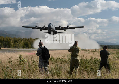 Gli osservatori di guardare un C-130 Hercules con la trentaseiesima Airlift Squadron da Yokota Air Base, Giappone, decollo di un austero pista utilizzata per la formazione durante la bandiera rossa-Alaska a base comune Elmendorf-Richardson, Alaska, 14 agosto 2015. La formazione ha permesso C-130 equipaggi alla pratica austera gli sbarchi e take offs, offload di combattimento e alimentazione gocce, ma ha anche consentito una competizione amichevole tra partecipanti forze dell'aria: U.S. Air Force, Giappone Aria forza di autodifesa, Royal Air Force, Royal Australian Air Force, Royal New Zealand Air Force e il Royal Thai Air Force. Condito C-130 equipaggi da ciascun paese giudicato Foto Stock