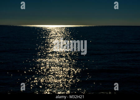 Il sole è splendenti, i suoi raggi andare al di là del mare di incontrarvi in spiaggia. La luce ci portano la vita. Foto Stock