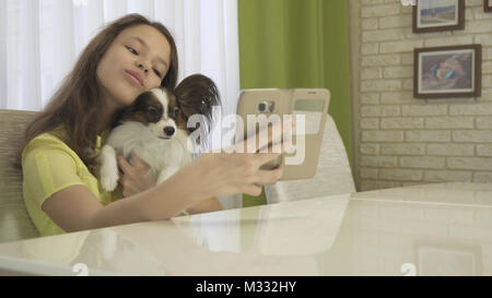 Felice ragazza adolescente facendo selfie con il suo cane Foto Stock