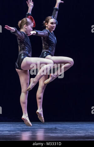 Dodici anni di ragazze che ballano sul palco facendo un salto di posa Foto Stock