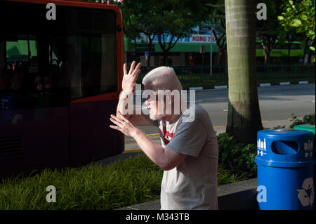 21.12.2017, Singapore, Repubblica di Singapore, in Asia - un uomo è visto la schermatura il suo volto da bassa sun a Singapore il quartiere Chinatown. Foto Stock