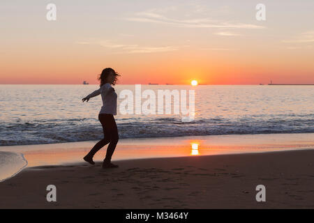 Woman Dancing sulla spiaggia al tramonto, Andalusia, Spagna Foto Stock