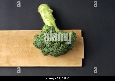 I broccoli e il bordo di taglio su sfondo scuro Foto Stock