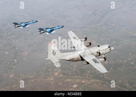 Due Bangladesh Air Force F-7BG difensori dal 5° Stormo, BAF Bangabandhu Base, escort a U.S. C-130H Hercules dal 374 Airlift Wing, Yokota Air Base, Giappone, durante l'esercizio a far fronte sud nei pressi di Kishoreganj, Bangladesh, Gennaio 28, 2015. Far fronte a sud è un Pacific Air Forces-sponsorizzato, bilaterali tactical airlift esercizio condotti in Bangladesh, con un focus sulla cooperativa Operazioni di volo, di giorno e di notte a basso livello di navigazione, tactical airdrop e aria-terra missioni come pure oggetto di scambi di esperti nei campi di operazioni di manutenzione e di armamento discipline. (U.S. Air Force foto di Foto Stock