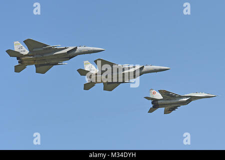 Due Stati Uniti Air Force F-15 aquile dalla 159Fighter Wing, Louisiana Air National Guard volare in formazione con un bulgaro MiG-29 di ritorno da una missione di addestramento di Graf Ignatievo Air Base, vicino a Plovdiv, Bulgaria, 23 aprile 2015. La missione congiunta è progettata per dimostrare l'impegno condiviso e una stretta cooperazione con la Bulgaria e a tutti gli alleati della NATO sulla lotta contro una serie di enti regionali e le minacce globali. (U.S. Air National Guard foto di Master Sgt. Toby M. Valadie, 159Public Affairs Office/RILASCIATO) 150423-Z-VU198-048 dalla Louisiana National Guard Foto Stock