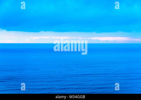 Stilizzato paesaggio astratto seascape tramonto lunga esposizione con le nuvole sotto diverse sfumature di blu, arancione, giallo e rosso Foto Stock