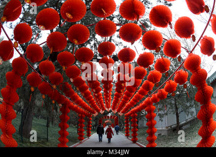 Pechino, Cina. Il 9 febbraio, 2018. I turisti a piedi sotto un corridoio decorato da lanterne rosse al Parco Ditan a Pechino Capitale della Cina, Febbraio 9, 2018. Un Festival di Primavera di tempio fiera si terrà presso il parco da febbraio 16 a 20. Credito: Luo Xiaoguang/Xinhua/Alamy Live News Foto Stock