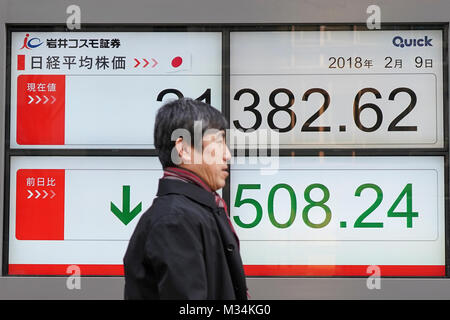 Tokyo, Giappone. Il 9 febbraio, 2018. Un uomo cammina davanti a un mercato azionario scheda indicatore a Tokyo in Giappone. Asia i mercati azionari immerso in maniera significativa dopo una settimana turbolenta sul Wall Street. Il Nikkei 225 è sceso più del tre per cento oggi e chiuso a 21,382.62 punti. Credito: AFLO/Alamy Live News Foto Stock