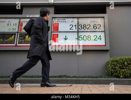 Tokyo, Giappone. Il 9 febbraio, 2018. Un uomo cammina davanti a un mercato azionario scheda indicatore a Tokyo in Giappone. Asia i mercati azionari immerso in maniera significativa dopo una settimana turbolenta sul Wall Street. Il Nikkei 225 è sceso più del tre per cento oggi e chiuso a 21,382.62 punti. Credito: AFLO/Alamy Live News Foto Stock