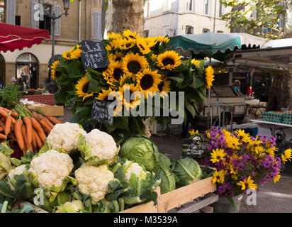 Verdure e girasoli per la vendita a l'aria aperta stallo a un mercato di agricoltori in Aix en Provence, Francia. Foto Stock