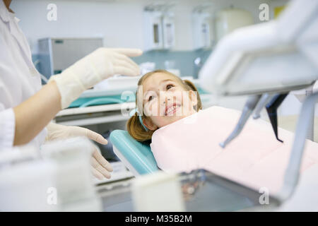 Bambina a studio dentistico, ottenere pronto per un normale checkup. Prevenzione, medico pediatrico in concetto di cura. Foto Stock