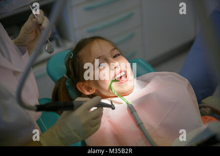 Bambina a studio dentistico, ottenere pronto per un trattamento della carie. Prevenzione, medico pediatrico in concetto di cura. Foto Stock